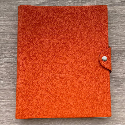 Hermes Ulysse MM Agenda Planner Notebook Cover with notebook refill - Pre-owned

Dimensions: about 17cm x 22cm (GM Size)

Brand: Hermes

Color: Orange

Material: calfskin